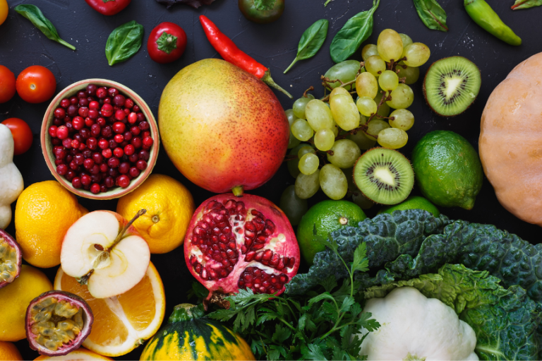 Buntes Gemüsegericht mit Reis, frischen Kräutern und Limettenhälften auf einem Tisch.